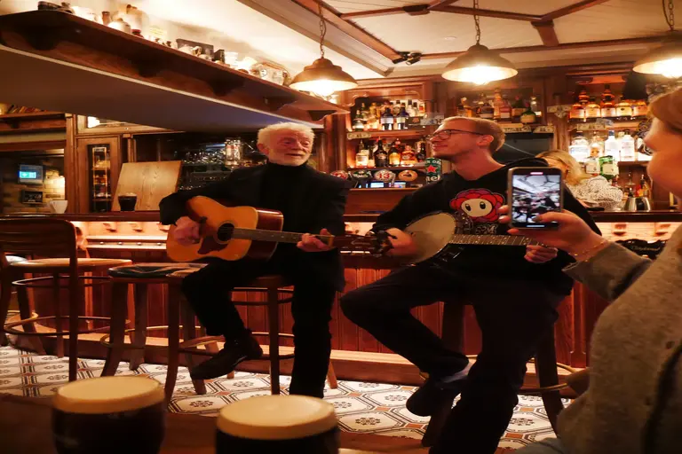 Livemusik im Irish Pub Musiker spielen Gitarre und Banjo in einem urigen irischen Pub – gemütliche Atmosphäre mit Live-Musik und Guinness.