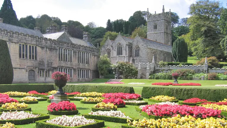 Das viktorianische Herrenhaus Lanhydrock House mit aufwendig angelegtem Blumengarten in Cornwall, England.