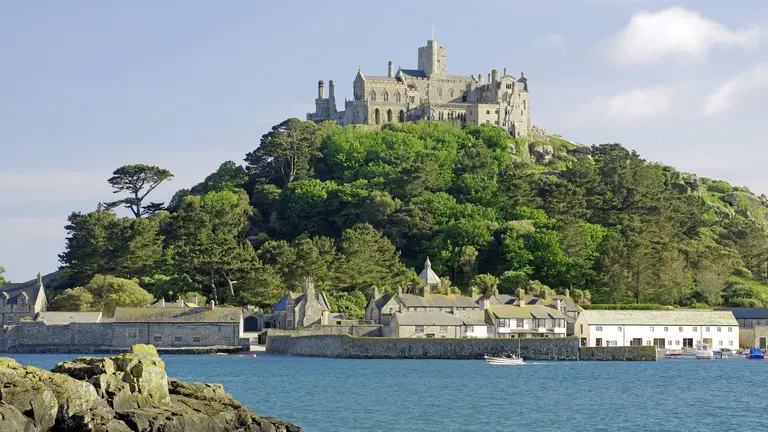St. Michael’s Mount, eine historische Kloster- und Burganlage auf einer Gezeiteninsel vor der Küste Cornwalls, umgeben von Meer und kleinen Häusern.