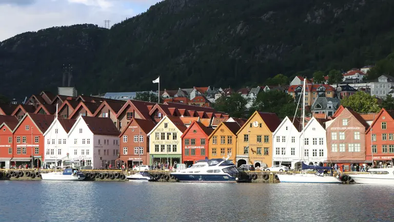 Das Hanseviertel Bryggen in Bergen Auf diesem Bild ist die berühmte Häuserzeile von Bryggen zu sehen, dem historischen Hanseviertel am Hafen von Bergen in Norwegen. Die bunten, eng aneinander stehenden Holzhäuser mit ihren Giebeldächern spiegeln die reiche Geschichte der Stadt wider und gehören zum UNESCO-Weltkulturerbe.