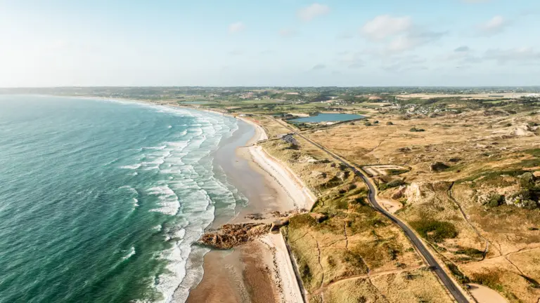 St. Quen´s Bay Man sieht eine Farbvolle und sich weit erstreckende Landschaft mit einem schönen Strand