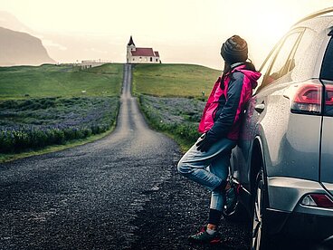 Person mit Auto in nordischer Landschaft