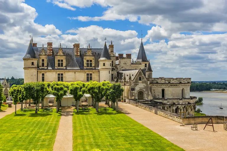 Das Schloss Chenonceau im Loiretal in Frankreich mit seinen eleganten Türmen und gepflegten Gartenanlagen. Die Renaissance-Architektur des berühmten Loire-Schlosses erstreckt sich über den Fluss Cher und ist von symmetrischen Rasenflächen und Blumenbeeten umgeben.