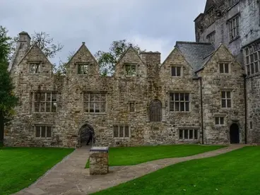 Zeitreise in Irland: Die beeindruckende Ruine von Donegal Castle Die imposante, aus Stein erbaute Ruine des Donegal Castle in der Grafschaft Donegal in Irland steht an einem bewölkten Tag auf einer saftig grünen Wiese und bietet als faszinierende historische Sehenswürdigkeit einen unvergesslichen Einblick in die irische Kultur und Geschichte während eines Urlaubs.