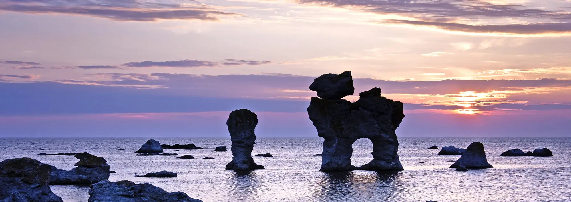 Markante Kalksteinfelsen, sogenannte Raukar, ragen im Abendlicht aus der Ostsee vor Gotland