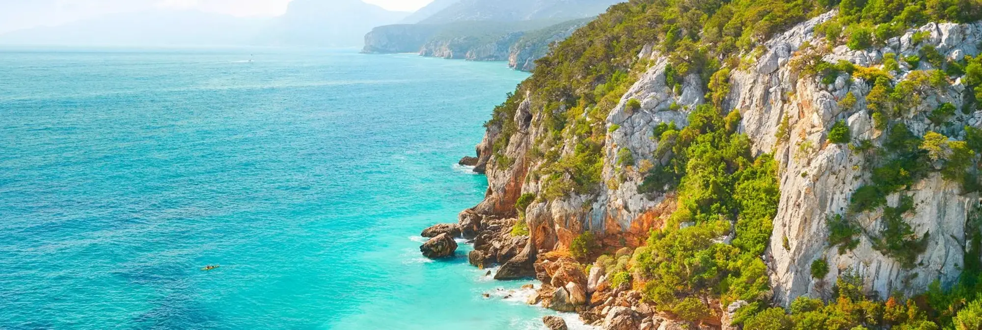 Küste von Sardinien Traumhafte Steilküste auf Sardinien mit türkisblauem Meer, grüner Vegetation und Felsen – ideale Kulisse für Urlaub in Italien.