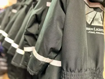 Eine Reihe warmer Thermo-Overalls hängt in Pyhä, Finnland, für Reisende bereit, um sie bei einem unvergesslichen Winter-Abenteuer in der arktischen Natur Lapplands zuverlässig vor der Kälte zu schützen und den Urlaub sicher zu gestalten.