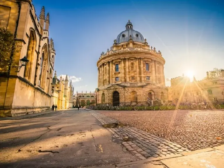 Die Radcliffe Camera, eine runde Bibliothek der Universität Oxford, im Sonnenlicht auf dem historischen Universitätsgelände.