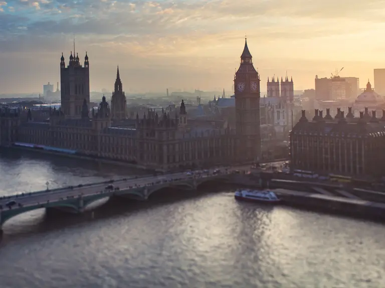 Ein stimmungsvoller Blick auf die Themse in London bei Sonnenuntergang. Im goldenen Licht erheben sich das berühmte Parlamentsgebäude und der Big Ben neben der Westminster Bridge. Das Bild fängt die Atmosphäre der britischen Hauptstadt perfekt ein – eine Mischung aus Geschichte, Kultur und moderner Eleganz.