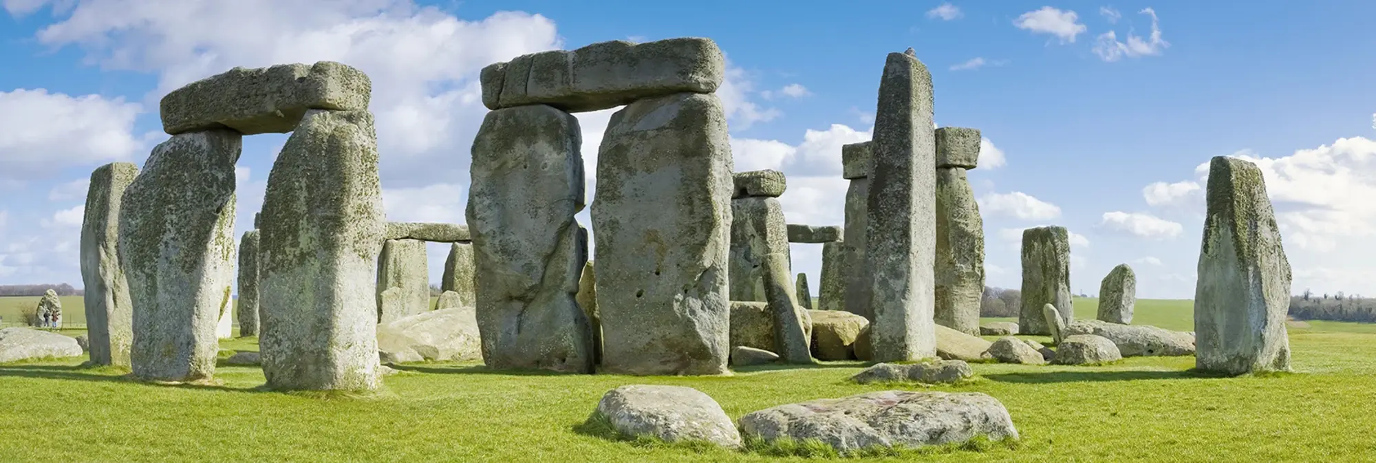 Das weltberühmte Monument Stonehenge in Südengland mit seinen mächtigen Steinkreisen, umgeben von grünen Wiesen und blauem Himmel, gilt als eines der bedeutendsten prähistorischen Bauwerke Europas.