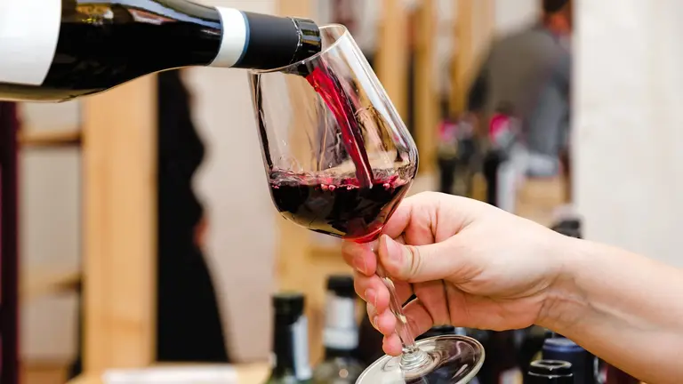 Rotwein wird in ein Glas eingeschenkt – Symbol für die lange Weinkultur Italiens.