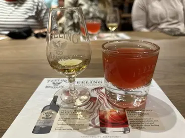 Teeling Irish Whiskey: Ein unvergessliches Tasting-Erlebnis in Dublin Ein Glas Teeling Irish Whiskey und ein leuchtend roter Whiskey-Cocktail stehen während einer Verkostung in der Teeling Destillerie in Dublin, Irland, bereit und laden zu einem unvergesslichen kulinarischen Erlebnis ein, das die moderne Kultur des irischen Whiskeys auf einer Reise erlebbar macht.